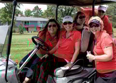Smiling people in a golf cart